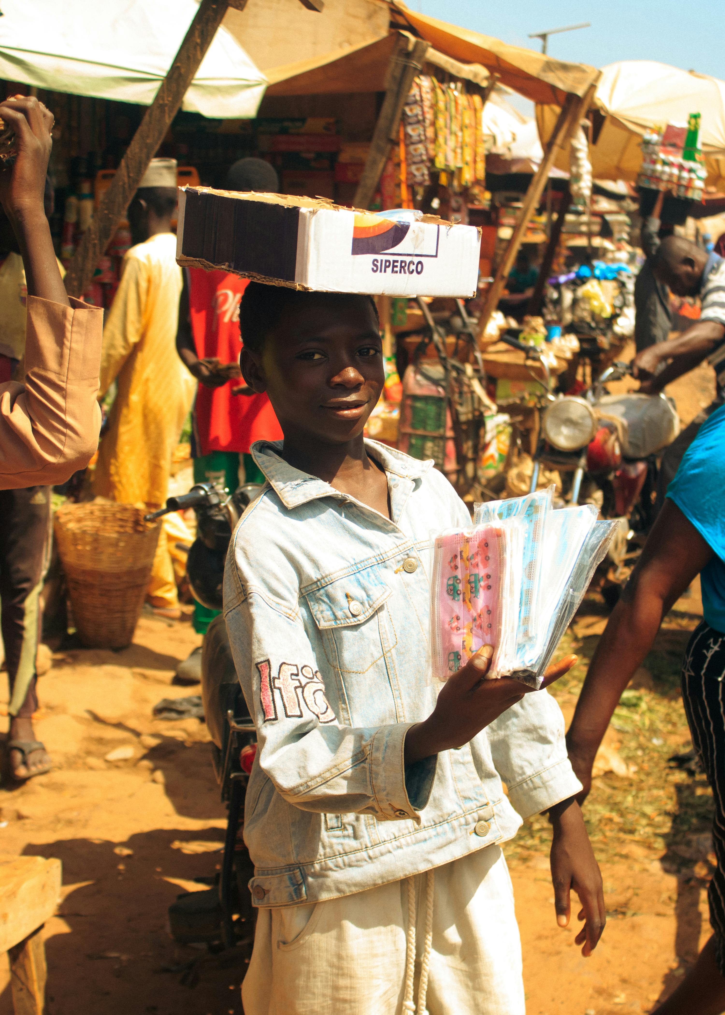 Jeune vendeur dans un marché africain illustrant les réalités du secteur informel
